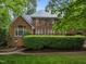Rear view of a brick home with a spacious deck and large windows, perfect for indoor/outdoor living at 541 The Preserve Trail Trl, Chapel Hill, NC 27517