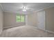 Bedroom with neutral carpet and paint, plus a window overlooking green trees at 541 The Preserve Trl, Chapel Hill, NC 27517