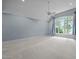 Bright, carpeted bedroom with a vaulted ceiling, a ceiling fan, and a large window overlooking a treed backyard at 541 The Preserve Trl, Chapel Hill, NC 27517