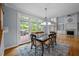 Bright dining room with glass doors to a deck, an elegant chandelier, and views of the living room at 541 The Preserve Trl, Chapel Hill, NC 27517