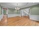 Dining room with chandelier, wood floors, and wainscoting is ready for entertaining at 541 The Preserve Trl, Chapel Hill, NC 27517