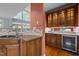 Close-up of the kitchen with granite counters, a tile backsplash, and a sink with a wine fridge at 541 The Preserve Trl, Chapel Hill, NC 27517