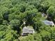 Stunning aerial view of a secluded home nestled among mature trees, offering privacy at 5601 Jomali Dr, Durham, NC 27705