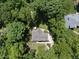 Overhead view of the home surrounded by lush greenery, deck, driveway, and walkways at 5601 Jomali Dr, Durham, NC 27705