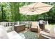 Outdoor living on the back deck with comfortable seating, umbrella, and a grill at 5601 Jomali Dr, Durham, NC 27705