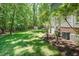 Spacious backyard with lush green grass, mature trees, and storage shed at 5601 Jomali Dr, Durham, NC 27705