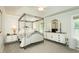 Well-lit main bedroom with a canopy bed frame, matching dressers, and a side table at 5601 Jomali Dr, Durham, NC 27705