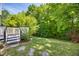 Green backyard with patio and landscaped with trees and bushes at 5865 Forest Point Rd Rd, Raleigh, NC 27610