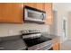 Kitchen features stainless steel appliances, wood cabinets, dark countertops, and an eat-in dining area at 5865 Forest Point Rd Rd, Raleigh, NC 27610