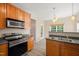 Cozy kitchen with stainless steel appliances, wood cabinets, and an eat-in dining area leading to the back patio at 5865 Forest Point Rd Rd, Raleigh, NC 27610