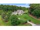 Aerial view of a home with lush landscaping, mature trees, and a long driveway at 60 Hartwood Ln, Youngsville, NC 27596