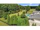 Aerial view of a pristine backyard showcasing a pool, lush greenery, mature trees, and ample lawn space at 60 Hartwood Ln, Youngsville, NC 27596