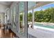 Covered back porch with a view of the pool and yard through glass doors at 60 Hartwood Ln, Youngsville, NC 27596