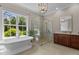Bright bathroom with a freestanding tub, glass shower, and large window overlooking nature at 60 Hartwood Ln, Youngsville, NC 27596