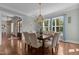 Elegant dining room with a chandelier, large windows, and a wood table with seating for eight at 60 Hartwood Ln, Youngsville, NC 27596