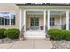 Inviting front entrance with columns, double doors, manicured landscaping, and stone accents at 60 Hartwood Ln, Youngsville, NC 27596