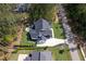 Stunning aerial view of a modern home with lush landscaping and a long driveway in a beautiful, wooded neighborhood at 604 Dappled Pine Ave, Durham, NC 27713