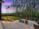 Relaxing backyard with paver patio, fire pit, seating area, and lush greenery overlooking wooded view at 604 Dappled Pine Ave, Durham, NC 27713