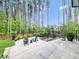 Landscaped backyard featuring a patio, seating area, and lush greenery and tall trees at 604 Dappled Pine Ave, Durham, NC 27713