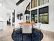 Elegant dining room features modern lighting, large windows, and a stylish round table with white upholstered chairs at 604 Dappled Pine Ave, Durham, NC 27713