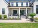 Inviting covered front porch with seating and manicured landscaping, complementing the home's striking facade at 604 Dappled Pine Ave, Durham, NC 27713