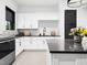 Modern kitchen features white cabinets, dark countertops, and stainless steel appliances for a sleek, contemporary design at 604 Dappled Pine Ave, Durham, NC 27713