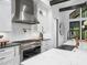 Bright, modern kitchen with stainless steel appliances, white cabinets, and dark wood beam accents at 604 Dappled Pine Ave, Durham, NC 27713