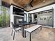 A covered patio area with a fireplace, TV, and an outdoor dining set at 604 Dappled Pine Ave, Durham, NC 27713
