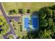 Aerial view of blue tennis courts and parking area amidst lush greenery and trees at 604 Dappled Pine Ave, Durham, NC 27713