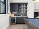 Wet bar with black cabinets, wine fridge, tiled backsplash, and sleek countertops at 604 Dappled Pine Ave, Durham, NC 27713