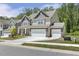 Beautiful home exterior with a large driveway, three-car garage, and well-manicured lawn in a serene neighborhood at 605 Hampton Crest Ct, Fuquay Varina, NC 27526
