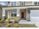 Inviting front porch with stone accents, a mahogany front door, and meticulously landscaped garden at 605 Hampton Crest Ct, Fuquay Varina, NC 27526