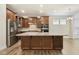 Well-lit kitchen featuring wood cabinetry, a stainless steel refrigerator, and a center island with granite countertops at 605 Hampton Crest Ct, Fuquay Varina, NC 27526