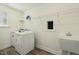 Bright laundry room with washer, dryer, sink, window, and wire shelf at 605 Hampton Crest Ct, Fuquay Varina, NC 27526