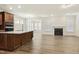 Open-concept living area with modern fireplace, wood floors, and a seamless flow to the kitchen and dining space at 605 Hampton Crest Ct, Fuquay Varina, NC 27526