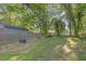 Large, lush backyard with a wooden fence, mature trees, and room for outdoor activities at 610 N Driver St, Durham, NC 27703