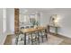 Dining room with a rustic wood table, modern chairs, and an exposed brick accent wall at 610 N Driver St, Durham, NC 27703