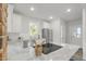 Bright kitchen featuring stainless steel appliances, granite counters, white cabinets, and an island with cooktop at 610 N Driver St, Durham, NC 27703