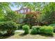 Brick building partially obscured by lush trees and landscaping, featuring large windows and a well-maintained lawn at 620 Martin Luther King Jr Blvd # Apt 502, Chapel Hill, NC 27514