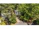 Aerial view of the home surrounded by mature trees shows the roof, chimney, driveway, and landscaping at 6904 Sandringham Dr, Raleigh, NC 27613