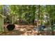 Spacious backyard with a patio featuring a grill and a cozy firepit area with Adirondack chairs at 6904 Sandringham Dr, Raleigh, NC 27613