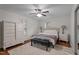 Cozy bedroom features hardwood floors, neutral decor, a ceiling fan and bright windows at 6904 Sandringham Dr, Raleigh, NC 27613