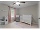 Neutral bedroom offers a window, ceiling fan, and a play kitchen at 6904 Sandringham Dr, Raleigh, NC 27613