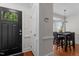 Inviting entryway features a black front door with glass panes and hardwood floors, offering a glimpse into the dining area at 6904 Sandringham Dr, Raleigh, NC 27613