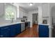 Well-appointed kitchen with white cabinets, blue accents, stainless steel appliances, and hardwood floors at 6904 Sandringham Dr, Raleigh, NC 27613