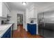 Well-appointed kitchen featuring white cabinets, blue accents, stainless steel appliances, and view to living area at 6904 Sandringham Dr, Raleigh, NC 27613