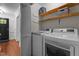 Functional laundry room with wood shelves above a modern washer and dryer set at 6904 Sandringham Dr, Raleigh, NC 27613
