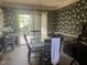 Dining room with a chandelier and a glass-top table surrounded by dark wallpapered walls at 713 Beddingfield Dr, Knightdale, NC 27545