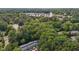 An aerial view of a wooded neighborhood with a commercial center and roadway in the distance at 7407 Sandy Creek Dr, Raleigh, NC 27615