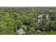 A high aerial view shows a house surrounded by lush green trees and neighborhood roads at 7407 Sandy Creek Dr, Raleigh, NC 27615
